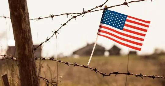 Barbed wire with American flag in the background